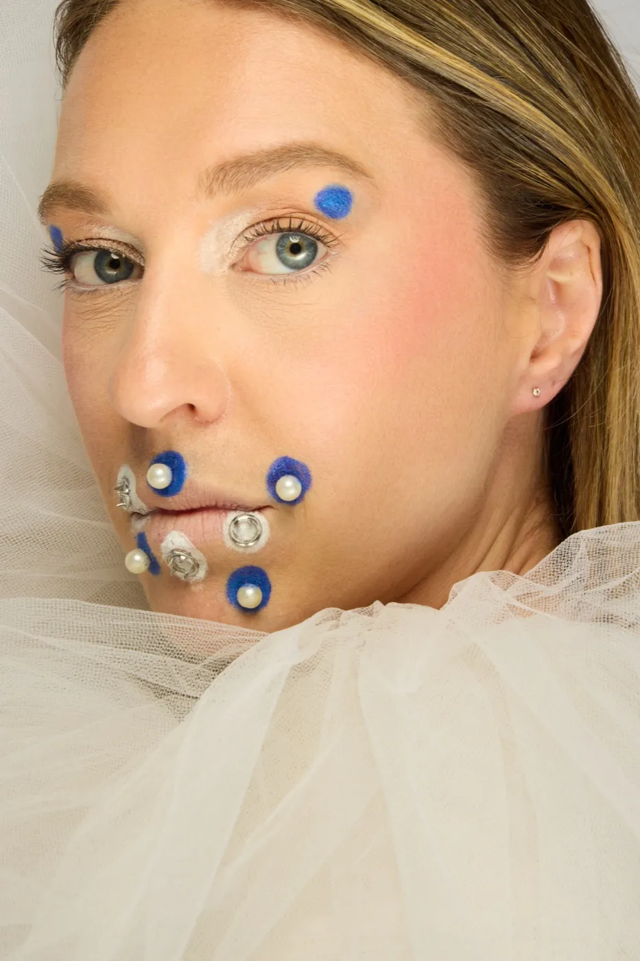 Maquillage créatif couture : perles et pompons bleus sur tulle blanc