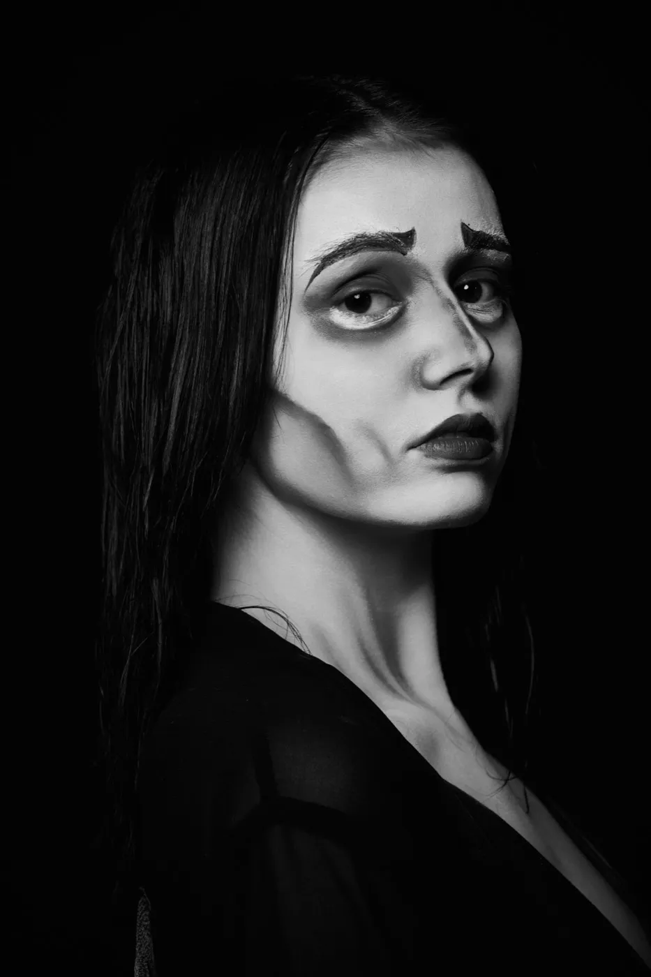 Maquillage théâtral en noir et blanc, clair-obscur dramatique