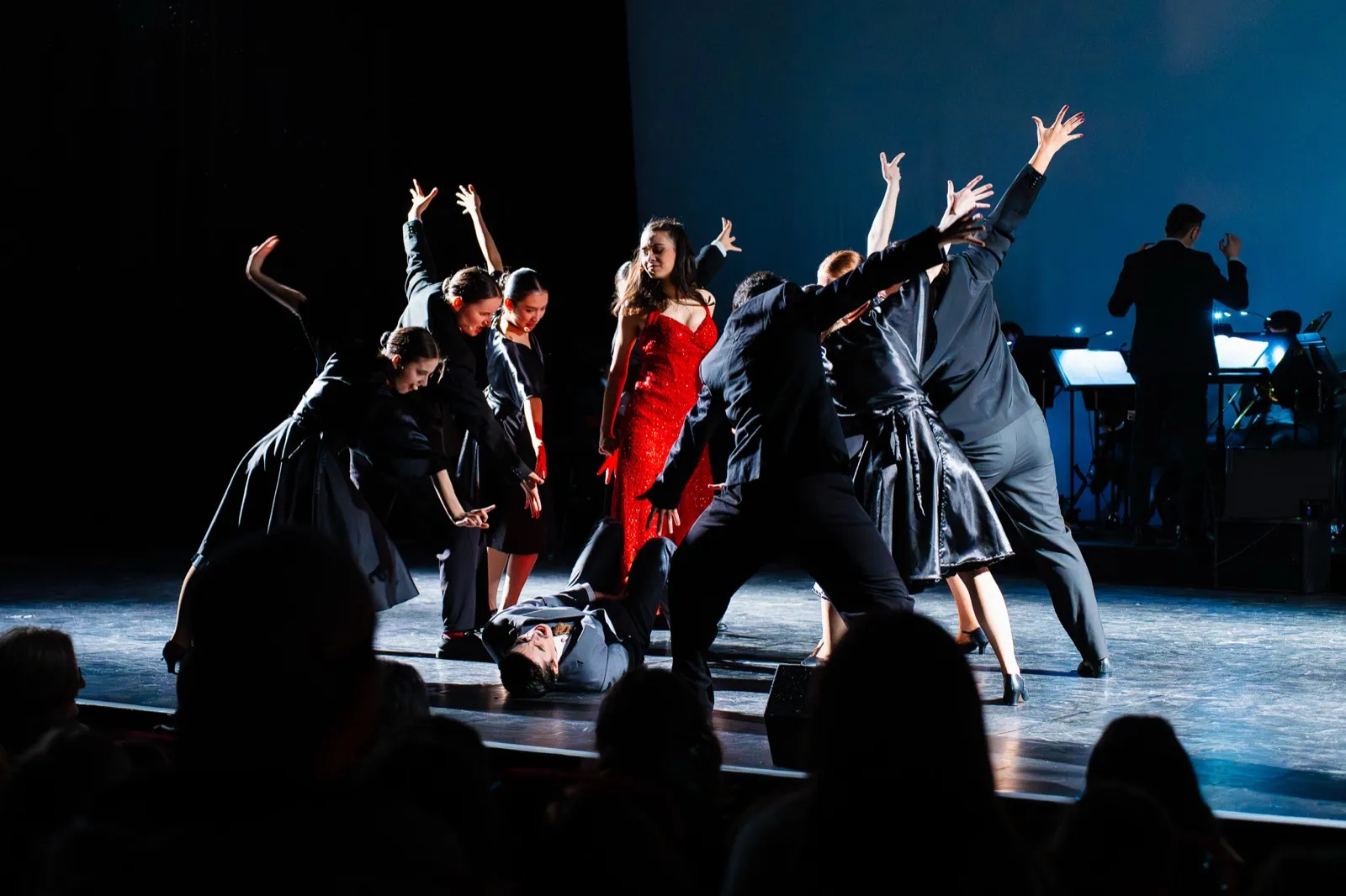 Ensemble dansé bras levés autour de la soliste en rouge