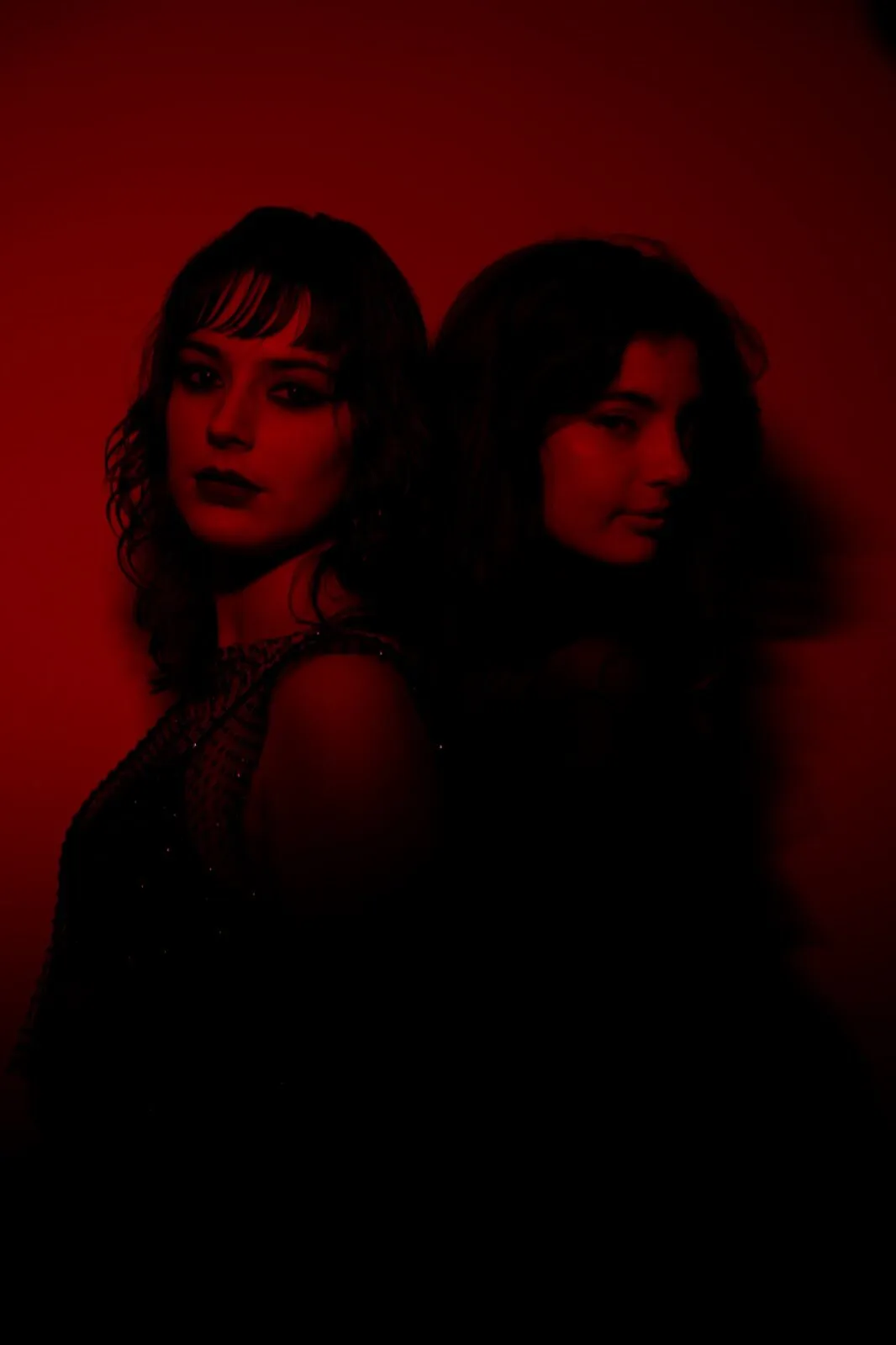 Duo rapproché sous lumière rouge, regards croisés